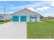 Single-story home with a two-car garage, shutters and a lovely green lawn at 701 Brigadoon Cir, Leesburg, FL 34788