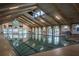 Large, well-lit indoor pool with a vaulted wood ceiling and multiple entry points at 701 Brigadoon Cir, Leesburg, FL 34788