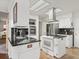 Well-lit kitchen with modern appliances, black countertops, and ample cabinet space at 701 Brigadoon Cir, Leesburg, FL 34788