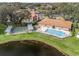 Aerial view of a community pool, shuffleboard court, and adjacent clubhouse at 701 Brigadoon Cir, Leesburg, FL 34788