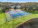 Aerial view of the tennis courts next to a pond on a sunny day at 701 Brigadoon Cir, Leesburg, FL 34788