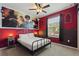 Themed bedroom with red walls, unique decor, and a comfortable queen-size bed at 7581 Oak Spring Ln, Davenport, FL 33837