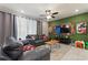 Spacious living room with dark leather furniture, ceiling fan, and a decorative accent wall at 7581 Oak Spring Ln, Davenport, FL 33837