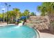 Resort-style pool featuring two water slides and a rock waterfall feature surrounded by palm trees at 7581 Oak Spring Ln, Davenport, FL 33837