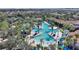 Aerial view of a community pool featuring waterslides, lounge chairs, and lush tropical landscaping and umbrellas at 7581 Oak Spring Ln, Davenport, FL 33837