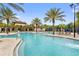 Stunning community pool with palm trees, lounge chairs and cabanas offer a relaxing atmosphere at 7581 Oak Spring Ln, Davenport, FL 33837