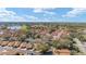 Expansive aerial shot of the residential area showcasing houses, a golf course, and a lake at 922 Cancun Ct, The Villages, FL 32159