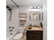 Cozy bathroom features a shower-tub combo, dark fixtures, and a granite-topped vanity at 922 Cancun Ct, The Villages, FL 32159