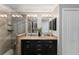 Beautiful bathroom with a glass shower, double sinks with granite counters, and dark cabinetry at 922 Cancun Ct, The Villages, FL 32159