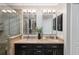 Beautiful bathroom with a glass shower, double sinks with granite counters, and dark cabinetry at 922 Cancun Ct, The Villages, FL 32159