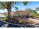 Street view of landscaped corner lot with bench, mature trees, and walkway to the house at 922 Cancun Ct, The Villages, FL 32159