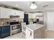 Well-lit kitchen with stainless steel appliances, marble countertops, and a cozy breakfast bar at 922 Cancun Ct, The Villages, FL 32159