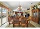 Elegant dining room featuring a chandelier, views of the living area, and easy access to the outdoor patio at 932 Medira Dr, The Villages, FL 32159