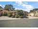 Landscaped home exterior featuring a circular driveway and vibrant tropical plants under a sunny sky at 932 Medira Dr, The Villages, FL 32159