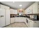 Well-lit kitchen with white cabinets, granite countertops, and tile flooring, ideal for culinary enthusiasts at 932 Medira Dr, The Villages, FL 32159