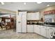 Well-lit kitchen featuring white cabinetry, black countertops, and stainless steel appliances at 932 Medira Dr, The Villages, FL 32159