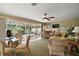 Spacious living room with wicker furniture, ceiling fan, and a bar with a hot tub outside at 932 Medira Dr, The Villages, FL 32159