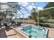 Exterior pool with a covered patio and lots of seating surrounded by lush greenery at 932 Medira Dr, The Villages, FL 32159