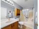 Cozy bathroom with wood vanity, tub, and showerhead at 17454 Se 81St Newberry Ct, The Villages, FL 32162