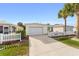 Clean single-story home featuring an attached garage, long driveway, and a beautiful lawn at 17454 Se 81St Newberry Ct, The Villages, FL 32162