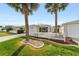 Attractive single-story home featuring a cozy sunroom, attached garage, and mature palm trees at 17454 Se 81St Newberry Ct, The Villages, FL 32162