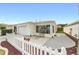 Inviting single-story home featuring a cozy sunroom, attached garage, and a white picket fence at 17454 Se 81St Newberry Ct, The Villages, FL 32162