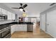 Modern kitchen with stainless steel appliances and white cabinets adjacent to the dining room at 17454 Se 81St Newberry Ct, The Villages, FL 32162