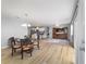 Open concept living room features a dining area, wood flooring and a view into the kitchen at 17454 Se 81St Newberry Ct, The Villages, FL 32162