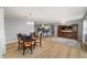 Open concept living room features a dining area, wood flooring and a view into the kitchen at 17454 Se 81St Newberry Ct, The Villages, FL 32162