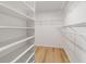 Walk-in closet with wooden floor and white shelves, offering ample storage space at 17454 Se 81St Newberry Ct, The Villages, FL 32162