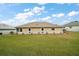 Backyard view of a cozy single-story house with well-maintained green lawn at 11053 Se 174Th Loop, Summerfield, FL 34491