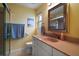 Bright bathroom featuring a peach colored countertop, white cabinets, and shower with glass door at 11053 Se 174Th Loop, Summerfield, FL 34491