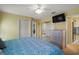 Bright bedroom with yellow walls featuring a bed, mirrored closet doors, and TV mounted on wall at 11053 Se 174Th Loop, Summerfield, FL 34491