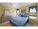 Cozy bedroom with yellow walls, tile floor, a ceiling fan, and abundant natural light at 11053 Se 174Th Loop, Summerfield, FL 34491