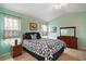 Bedroom with a vaulted ceiling, mint-green walls, tile flooring, and classic dark wood furniture at 11053 Se 174Th Loop, Summerfield, FL 34491