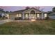 Charming single-story home featuring a well-manicured lawn and inviting entrance with white columns at 11053 Se 174Th Loop, Summerfield, FL 34491