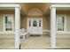 Inviting front porch with columns, seating, and decorative door wreath at 11053 Se 174Th Loop, Summerfield, FL 34491
