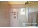 Modern shower with glass door, rainfall shower head, and accessible grab bars for convenience at 11053 Se 174Th Loop, Summerfield, FL 34491