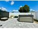 Backyard with a hot tub on a stamped concrete patio, surrounded by a white privacy fence and green foliage at 1209 Demoiselle St, Groveland, FL 34736