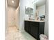Bathroom featuring a dark vanity cabinet, tiled floors, and a door leading to another area at 1209 Demoiselle St, Groveland, FL 34736