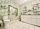 Bathroom with ample counter space, tile floors, and unique floral wallpaper at 1209 Demoiselle St, Groveland, FL 34736
