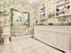 Bathroom featuring marble countertops, tile floors, and unique floral wallpaper at 1209 Demoiselle St, Groveland, FL 34736