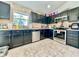 Kitchen featuring stainless steel appliances, dark cabinetry, and a neutral tile backsplash at 1209 Demoiselle St, Groveland, FL 34736