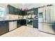 Kitchen featuring stainless steel appliances, black cabinetry, tile backsplash and tiled floor at 1209 Demoiselle St, Groveland, FL 34736