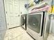 Laundry area with modern washer and dryer units, white cabinets, and stylish flooring at 1209 Demoiselle St, Groveland, FL 34736