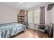 Bright bedroom with hardwood floors and natural light, furnished with a desk at 1212 Windy Bluff Dr, Minneola, FL 34715