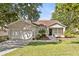 Charming single-story home with a well-maintained lawn and attached two-car garage at 1212 Windy Bluff Dr, Minneola, FL 34715