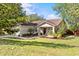 Inviting front exterior featuring a lush green lawn and charming landscaping around the entrance at 1212 Windy Bluff Dr, Minneola, FL 34715