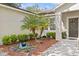 Landscaped front yard with a small palm and water feature along a stone and mulch walkway at 1212 Windy Bluff Dr, Minneola, FL 34715