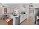 Bright kitchen featuring stainless steel appliances, white countertops, and an open layout to the dining area at 1212 Windy Bluff Dr, Minneola, FL 34715